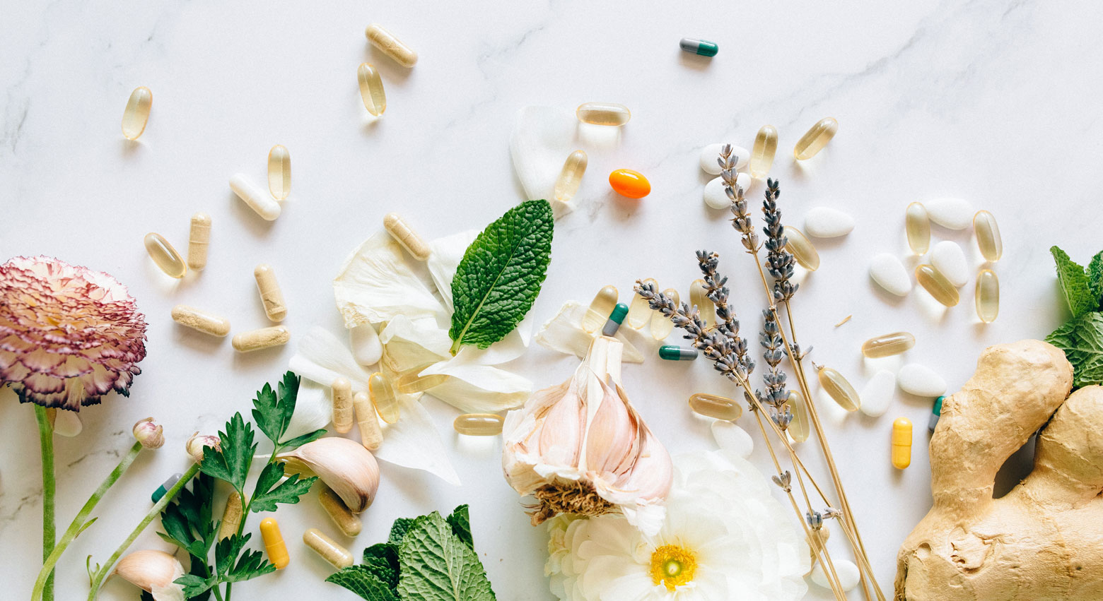 Symbolbild aus Kräutern, Blüten, Knoblauch, Ingwer, Lavendel und Kapseln